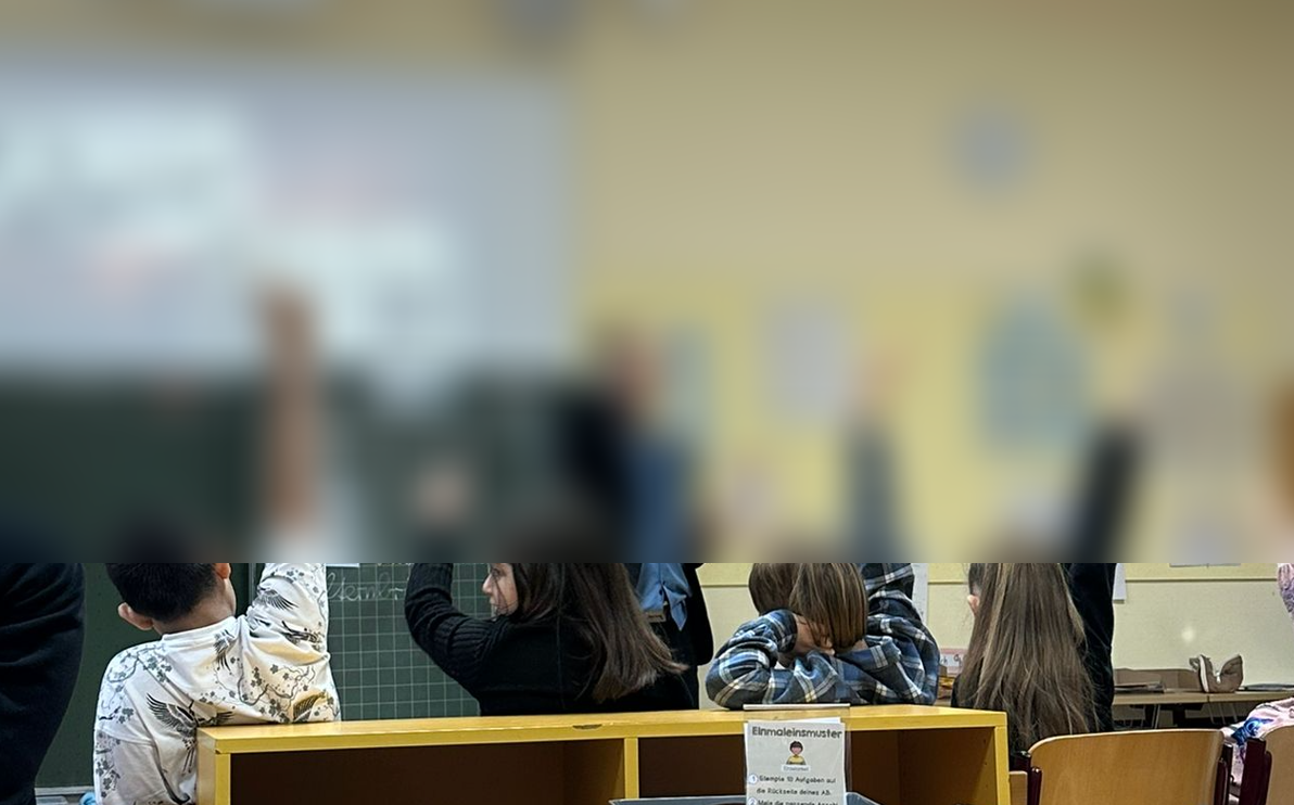 Schüler:innen mit erhobenen Händen — Gesichter aus Datenschutzgründen unkenntlich gemacht