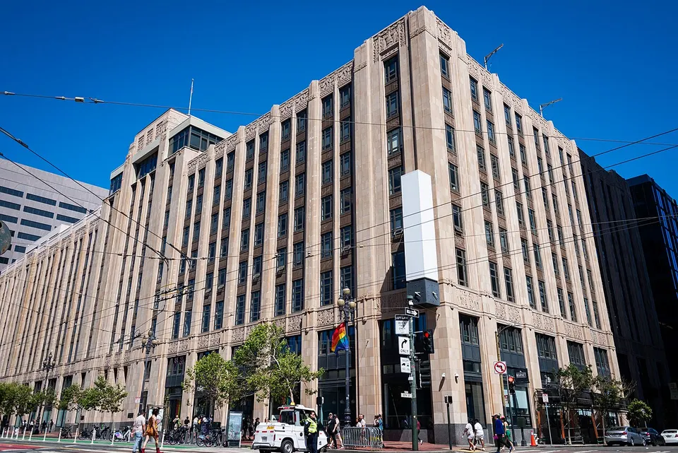 Hohes helles Art-déco-Bürogebäude an einer Straßenecke in San Francisco, vorne eine leere weiße Säule