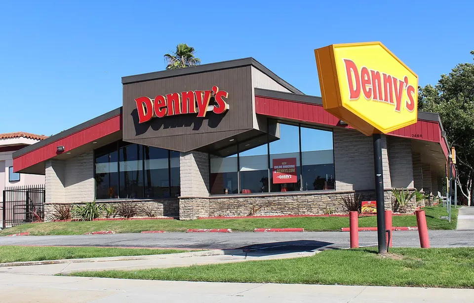 Ein Denny's-Diner mit rot-gelbem Schild an einer Straße in San Jose bei Sonne